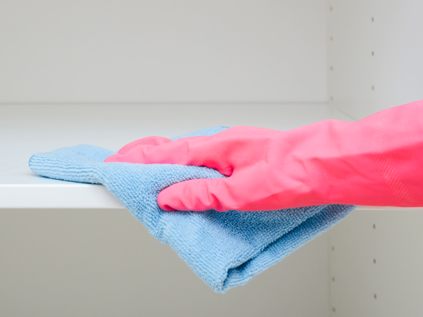 Kleiderschrank wird mit Lappen ausgewischt